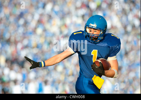 Calcio caucasica player in esecuzione con il calcio Foto Stock