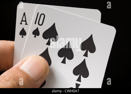 Le carte blackjack tenuto a mano su sfondo nero Foto Stock