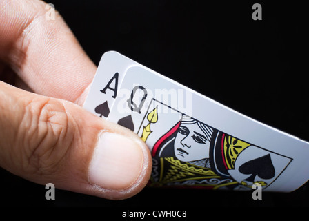 Le carte blackjack tenuto a mano su sfondo nero Foto Stock