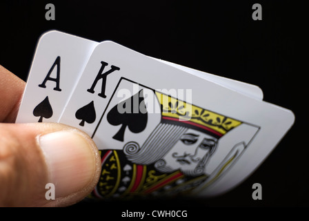 Le carte blackjack tenuto a mano su sfondo nero Foto Stock