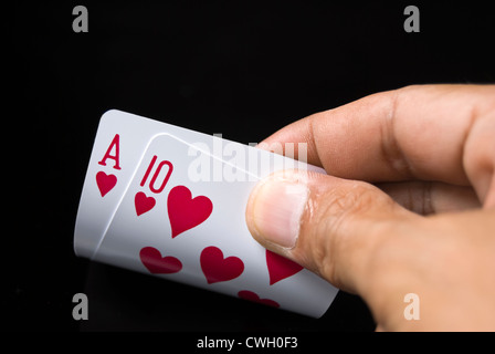 Le carte blackjack tenuto a mano su sfondo nero Foto Stock