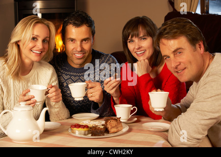 Un gruppo di persone di mezza età coppie godendo di tè e una fetta di torta insieme Foto Stock