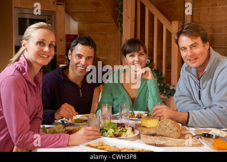 Gruppo di amici gustando pasti in Chalet Alpina insieme Foto Stock
