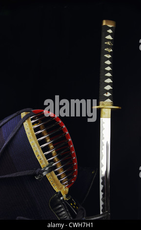 Casco di Kendo e spada katana su sfondo nero Foto Stock