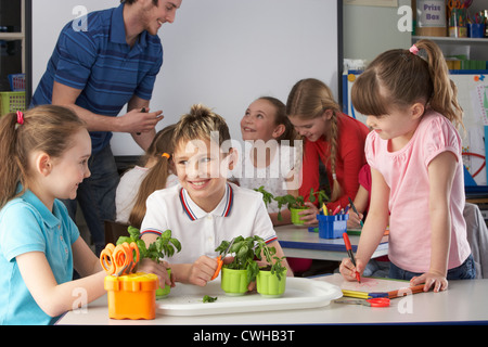 I bambini che imparano circa le piante nella classe della scuola Foto Stock