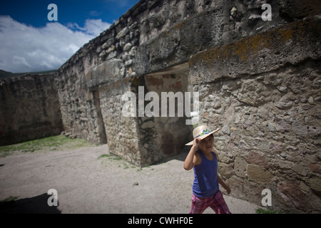 Una ragazza che indossa un cappello corre nel gruppo di chiesa del zapoteco le rovine di San Pablo Villa de Mitla, Oaxaca, Messico, Luglio 8, 2012. Foto Stock