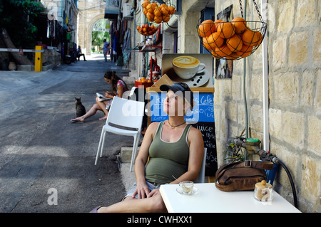 Donna incinta seduta in una strada laterale café Foto Stock