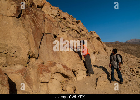 Guide peruviana sottolineando incisioni rupestri a Palpa Perù di petroglifi Chichictara America del Sud Foto Stock