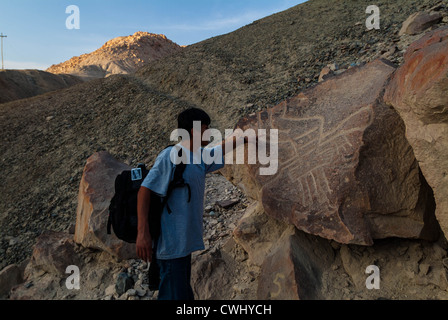 Uomo peruviano sottolineando i disegni in Palpa Perù di petroglifi Chichictara America del Sud Foto Stock