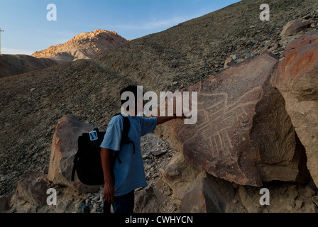 Uomo peruviano sottolineando i disegni in Palpa Perù di petroglifi Chichictara America del Sud Foto Stock