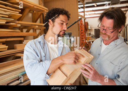 Co-lavoratori di macchine per la lavorazione del legno in officina Foto Stock