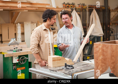 Co-lavoratori di macchine per la lavorazione del legno in officina Foto Stock