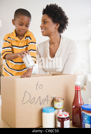 Nero madre e figlio di cibo di inscatolamento per donazione Foto Stock