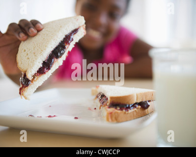 Nero Ragazza di mangiare il burro di arachidi e sandwich di gelatina Foto Stock