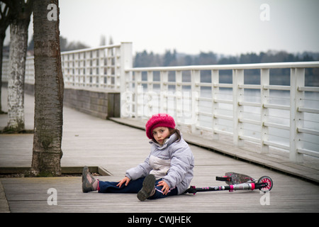 A 6 anni ragazza e il suo scooter su cui-out esplanade per pedoni e per chi ama fare jogging (Vichy-Allier - Francia). Foto Stock