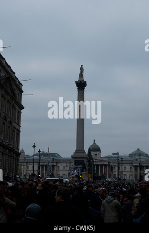 Nelson contro la colonna grigio cielo nuvoloso da Whitehall con grande folla di persone dopo la sfilata di capodanno Foto Stock