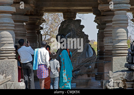 Persone che guardano il Nandi Bull monolite. Tempio Hoysaleswara. Halebidu. India Foto Stock