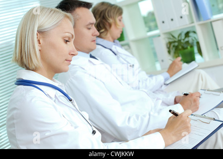 Ritratto di tre medici con cartelline rendendo note alla conferenza medica Foto Stock