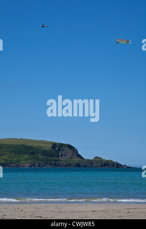 Spia traino aeromobili banner pubblicitario ,Daymer Bay beach nei pressi di roccia e Padstow, Cornwall, Inghilterra, Regno Unito. Foto Stock