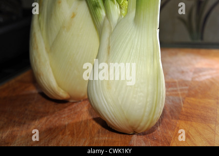 Le lampadine di finocchio sul tagliere di legno in cucina Foto Stock