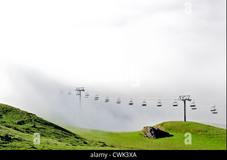 Seggiovia vuota nella nebbia a sunrise lungo il Col du Tourmalet nei Pirenei in estate, Francia Foto Stock