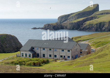 Fair Isle osservatorio ornitologico nelle isole Shetland con pecore Rock in background. Giugno 2012. Foto Stock