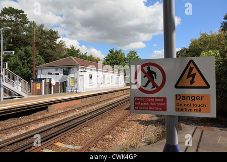 Elettrificata di binari ferroviari con segnaletica di pericolo attenzione ai passeggeri di non attraversare la via su Ashford alla linea di Londra Inghilterra Regno Unito Gran Bretagna Foto Stock