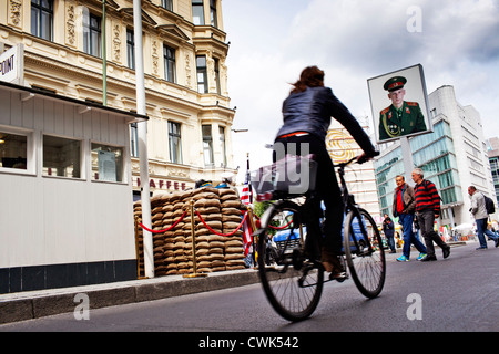 Una donna in sella a una moto al Checkpoint Charlie in Friedrichstrasse, Berlino Foto Stock