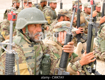 L Esercito nazionale afgano si siede mentre aspettavano il loro turno per mettere in pratica le azioni urban su un sito di formazione di Camp Hero Aprile 9, 2012 in Afghanistan meridionale. La formazione era parte di un quattro-settimana team leader corso che viene insegnata ai privati al fine di prepararli ad assumere il junior sottufficiale rank. Foto Stock