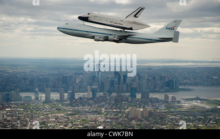 Lo Space Shuttle Enterprise, montata in cima ad un NASA 747 vettore navetta aeromobile è visto come si vola al di sopra dello Skyline di Manhattan con Freedom Tower in background Aprile 27, 2012 a New York. Enterprise è stata la prima navetta orbiter costruito per la NASA effettuare prove di voli in atmosfera ed era incapace di volo spaziale. Foto Stock