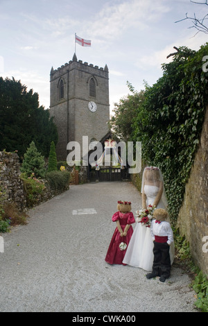 Scarecrows a kettlewell festival raffigurante la sposa damigella e la pagina di ragazzo di fronte alla chiesa Foto Stock