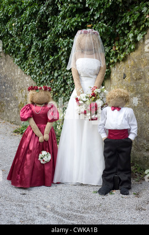 Scarecrows a kettlewell festival raffigurante la sposa damigella e la pagina di ragazzo di fronte alla chiesa Foto Stock