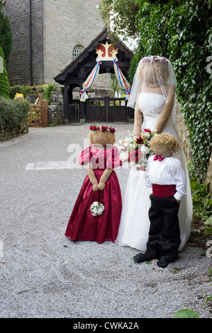 Scarecrows a kettlewell festival raffigurante la sposa damigella e la pagina di ragazzo di fronte alla chiesa Foto Stock