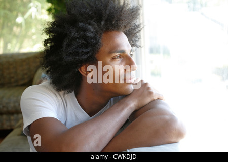 Uomo seduto sul divano pensando Foto Stock