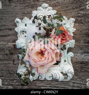 Vecchio telaio vintage, decorata con rose a secco e trifoglio su uno sfondo di legno Foto Stock