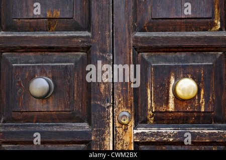 Ottone maniglie della porta e la serratura sulla vecchia porta di legno, Cecina Toscana Italia Foto Stock
