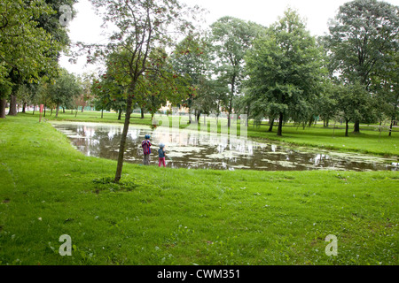 Bambini polacchi che gioca da città pond. Paderewski Park Rzeczyca Polonia centrale Foto Stock