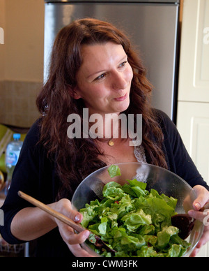 Piacere donna polacca età 32 con in mano un bicchiere di intestino insalata di verdure fresche nella sua cucina. Zawady Polonia centrale Foto Stock