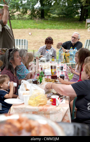 Extended quattro generazioni della famiglia polacca avente una cena all'aperto nel loro cortile. Zawady Polonia centrale Foto Stock