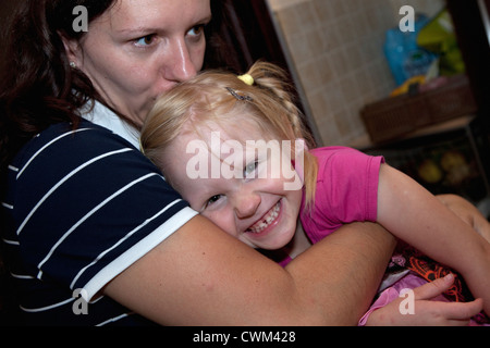 Felice ragazza polacca a casa sicuro nella sua madri età dei bracci 5 e 32. Zawady Polonia centrale Foto Stock