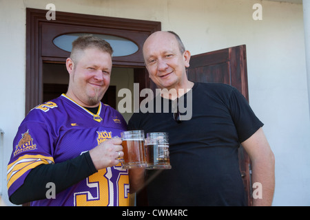 Padre polacco-in-legge e felice son-in-law avente un amichevole nostrovia toast con boccali di birra. Zawady Polonia centrale Foto Stock