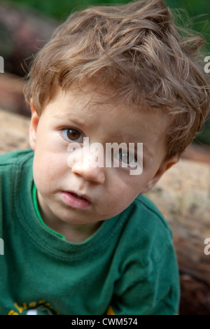 Stanco ragazzo polacco age 2 prendendo una pausa di bicicletta su registri su un sentiero di registrazione attraverso la foresta nazionale. Zawady Polonia centrale Foto Stock