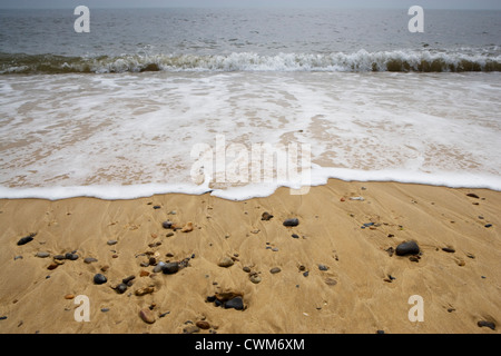 Basso angolo vista delle onde che si infrangono sulla battigia su di una spiaggia di sabbia. Foto Stock