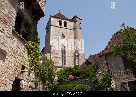 Guardando verso l'alto la chiesa medievale che si affaccia sul bellissimo villaggio di Saint-Cirq-Lapopie in molte regioni del sud-ovest della Francia. Foto Stock