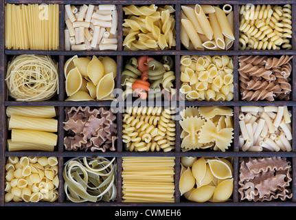 Diversi tipi di pasta essiccata in un vassoio di legno Foto Stock