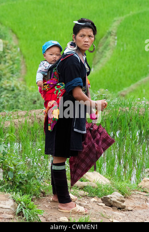 Donna Hmong porta il suo bambino sulla schiena di Sapa, Vietnam Foto Stock