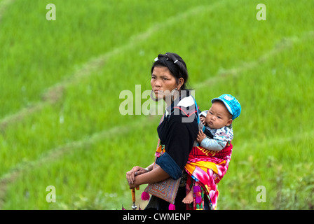 Donna Hmong porta il suo bambino sulla schiena di Sapa, Vietnam Foto Stock