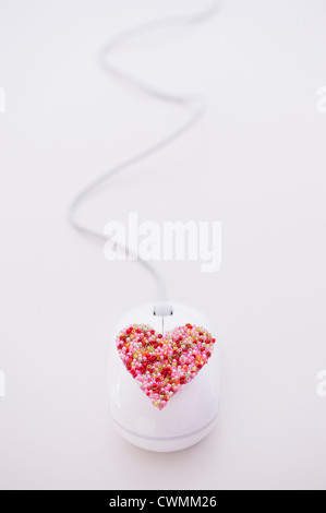 Cuore colorati sul mouse del computer Foto Stock