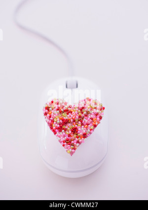 Cuore colorati sul mouse del computer Foto Stock