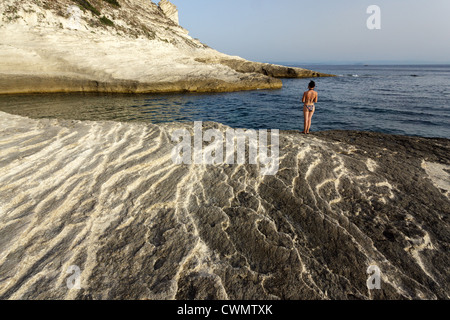 Donna in piedi sul litorale di calcare in Bonifacio, Corsica, Francia Foto Stock